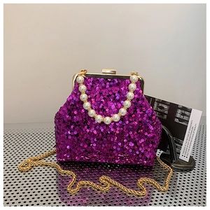 Detail der lila Pailletten-Muscheltasche mit Perlengriff und goldener Kette