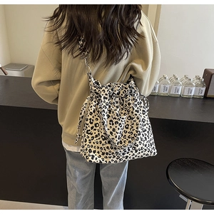 Detail of leopard print canvas tote bag featuring drawstring closure and slim shoulder strap