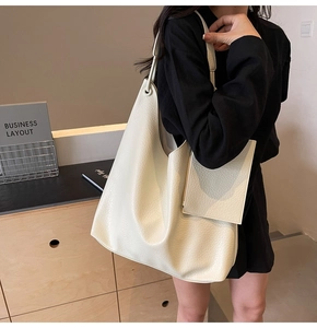 Détail d'un grand sac cabas crème en cuir grainé avec une petite pochette amovible