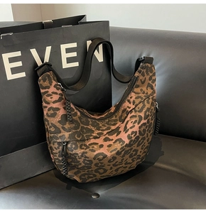 Detail of leopard print canvas bag showing texture, wide nylon strap and side pockets