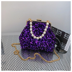 Detail der lila Pailletten-Abendtasche mit Perlengriff und goldener Kettenriemen