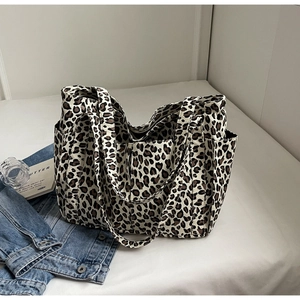 Vista dettagliata della borsa tote in tela leopardata con pratiche tasche laterali
