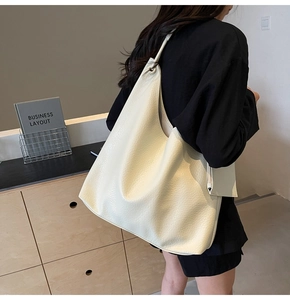Détail du sac hobo crème en cuir à motif lychee avec vue de profil par derrière