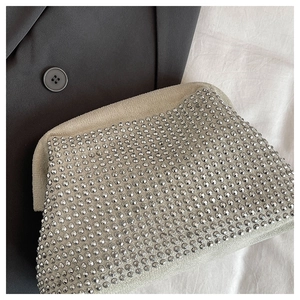 Macro view of silver rhinestone handbag showing the sparkling crystals and soft velvet texture