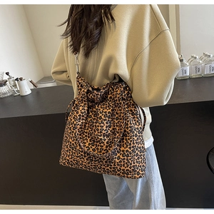 Detail showing high-quality leopard print canvas bag with durable metal hooks and black straps