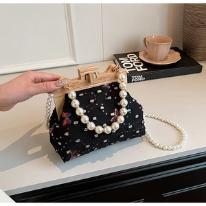 Detail of beaded shell bag with butterfly embroidery, wooden frame and pearl handle