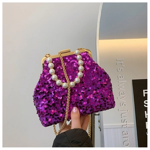 Detail der lila Pailletten-Muscheltasche mit Perlengriff und goldener Kette