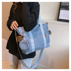 Detail of light blue nylon tote bag with beige straps and matching round coin purse
