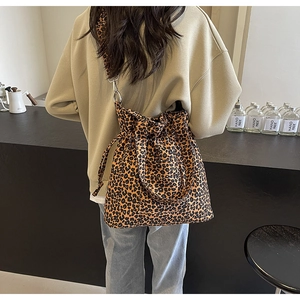 Detail of leopard print canvas bag with drawstring closure and wide shoulder strap