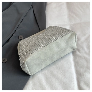 Detail of light gray matte crossbody bag with silver metal studs on soft fabric
