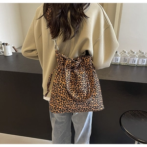 Detail of leopard print canvas bag showing drawstring closure and wide shoulder strap