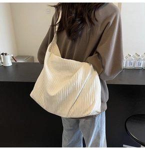 Nahaufnahme der weißen Cord-Hobo-Tasche mit gestreifter Textur und großem Fassungsvermögen