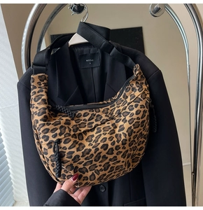 Detail view of leopard print canvas crescent bag with wide strap and side zipper