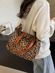 Stylish leopard print canvas tote bag with brown leather handles and adjustable strap