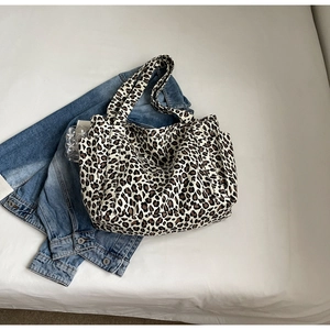 Dettaglio della borsa tote leopardata con tasca laterale e doppi manici robusti