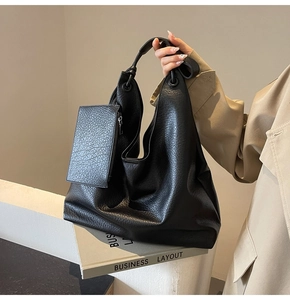 Détail du sac hobo en cuir grainé noir avec pochette zippée latérale et texture élégante