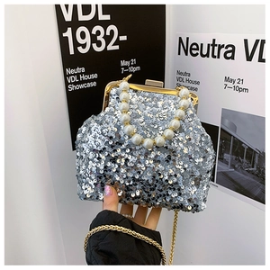 Detailaufnahme der silbernen Pailletten-Handtasche mit Perlengriff und goldener Kette