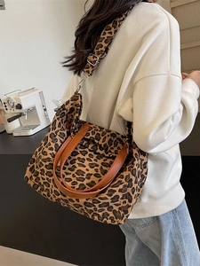 Large leopard print canvas tote bag with brown leather handles and wide shoulder strap