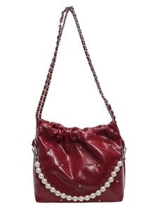 Bright red quilted leather bucket bag with silver studs and elegant pearl handle chain