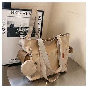 Detail of beige canvas tote with side brown flap pocket and circular zipper coin pouch