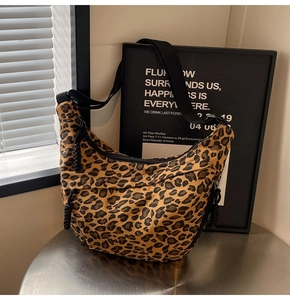 Close-up of leopard print canvas crescent bag with black woven zipper detail