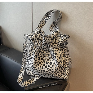 Detail view of leopard print canvas tote bag featuring drawstring closure and side pocket