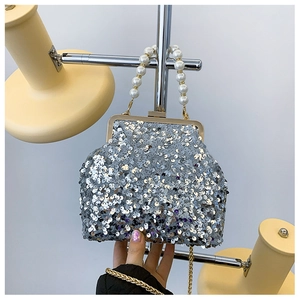 Detailansicht einer silbernen Pailletten-Abendtasche mit Perlengriff und goldener Kette