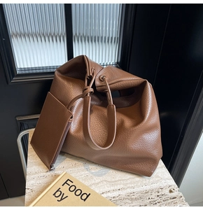 Détail d'un grand sac fourre-tout marron grainé avec une petite pochette assortie