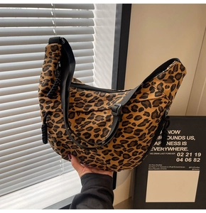 Detail of leopard print canvas crescent bag with black wide strap and knot zipper puller
