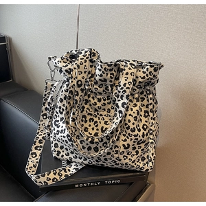 Detail of leopard print tote bag with drawstring closure and detachable strap