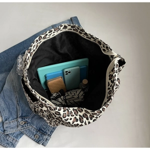 Vista dall'alto dell'interno della borsa leopardata con tablet, portafoglio e accessori