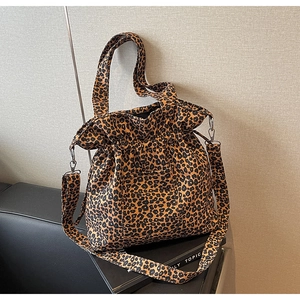 Detailed view of leopard print canvas bag with detachable wide strap and sturdy handles