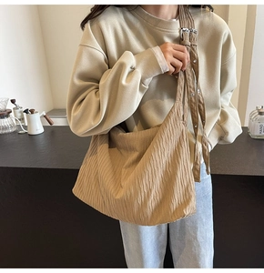 Detailansicht der khakifarbenen Cord-Tasche mit verstellbaren Silberschnallen und Falten