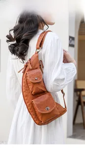Détail d'un sac de poitrine en cuir marron vintage avec deux poches et boucles en métal