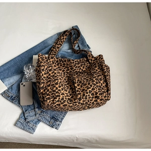 Vista piatta della borsa tote in tela leopardata con tasche multiple e manici