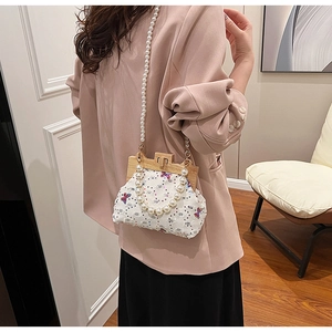 Detail of white tweed bag with colorful butterfly embroidery and pearl chain strap
