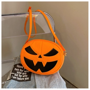 Detail of pumpkin-shaped crossbody bag with Jack-o'-lantern face and adjustable strap