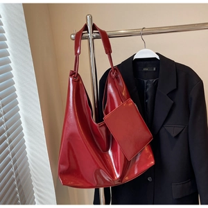 Detailed view of high-gloss red hobo bag with matching pouch and polished surface