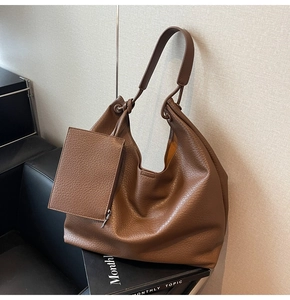 Gros plan du grand sac cabas marron en similicuir avec sa pochette zippée assortie