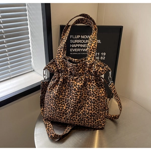 Detail of leopard print canvas tote bag with adjustable shoulder strap and drawstring closure
