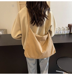 Rückansicht eines Modells mit einer beige plissierten Cord-Tasche im modernen Raum