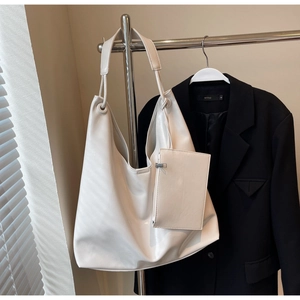 Detail of off-white large hobo bag with matching mini pouch and stylish knot handle