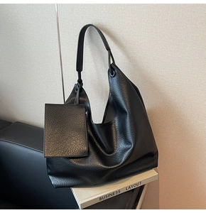 Détail du sac Hobo en cuir grainé noir avec un porte-monnaie carré amovible assorti