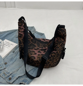 Detail of leopard print canvas bag with adjustable wide strap and secure zipper closure