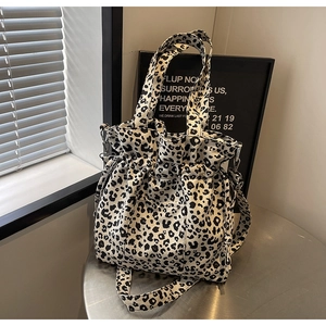 Detail of leopard print canvas tote bag with drawstring closure and outer pocket