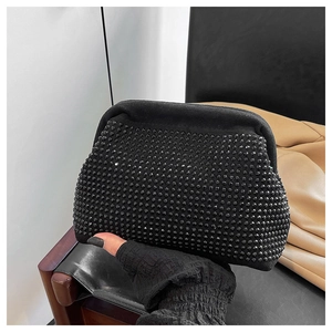Macro shot of black shell-shaped evening bag with studded texture and matte finish