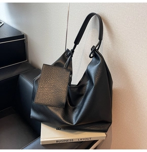 Détail du grand sac cabas noir en cuir avec bandoulière large et petite pochette