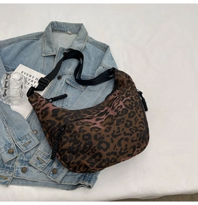 Detail of leopard print hobo bag with adjustable black strap and woven zipper pull