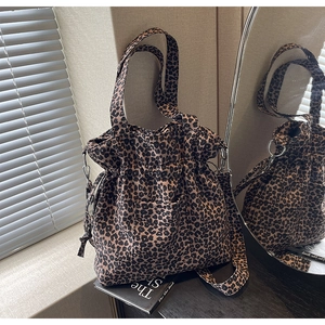 Detail of leopard print canvas bag showing drawstring closure and brown texture