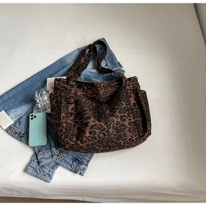 Dettaglio della borsa tote leopardata con tasche laterali funzionali e trama in tela